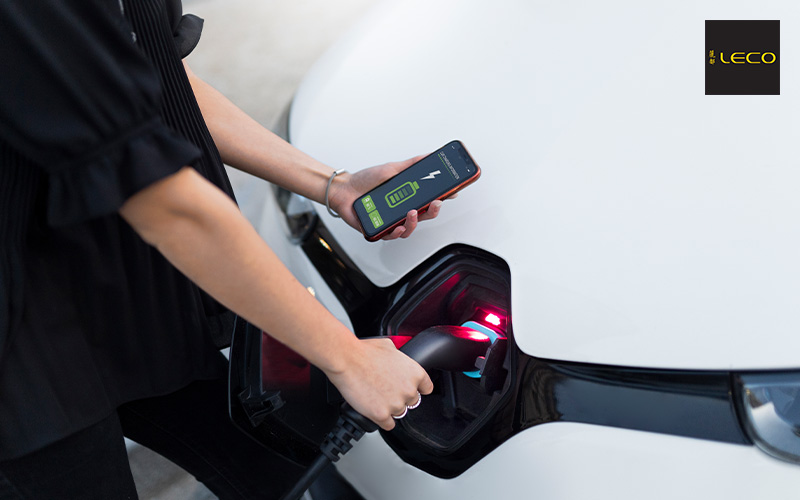 Charging an electric vehicle while monitoring costs on smartphone.