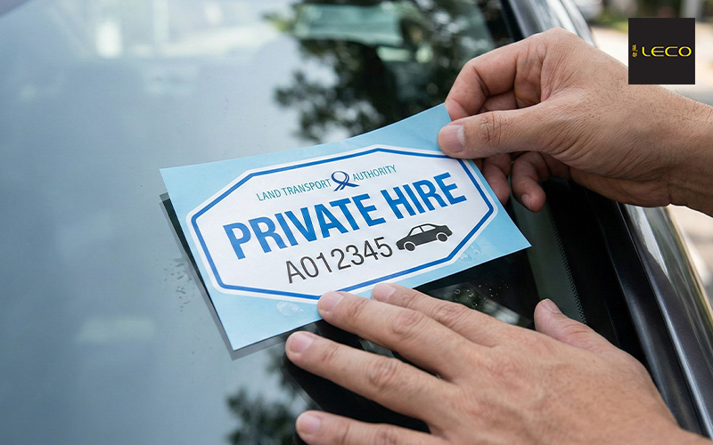 Hands placing a Land Transport Authority Private Hire decal.